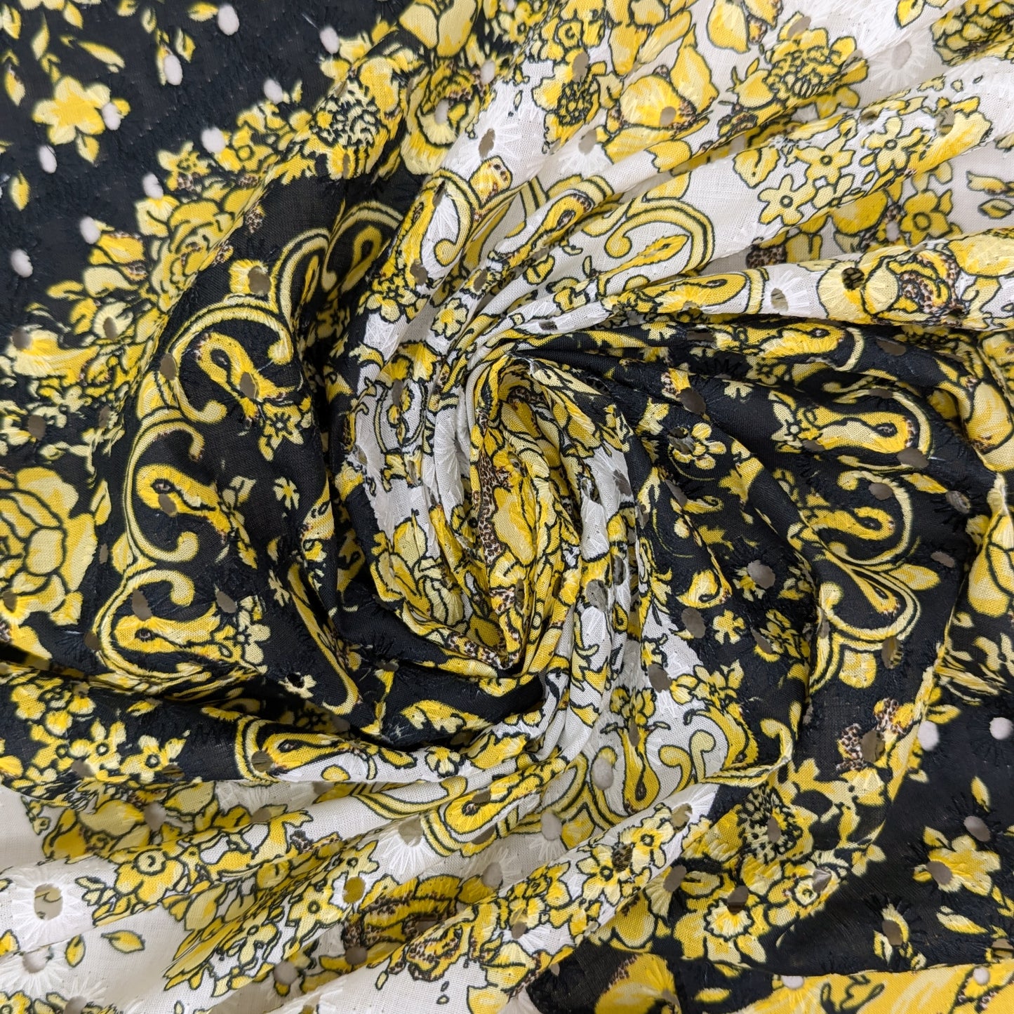 Black, white, and yellow Sangallo lace fabric with Medusa print and floral patterns.