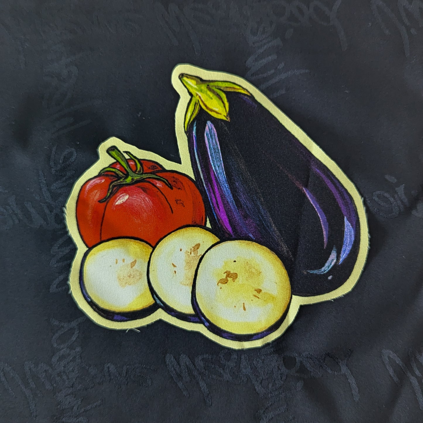 Printed patch with a purple eggplant, red tomato, and three yellow eggplant slices, 15x15cm.