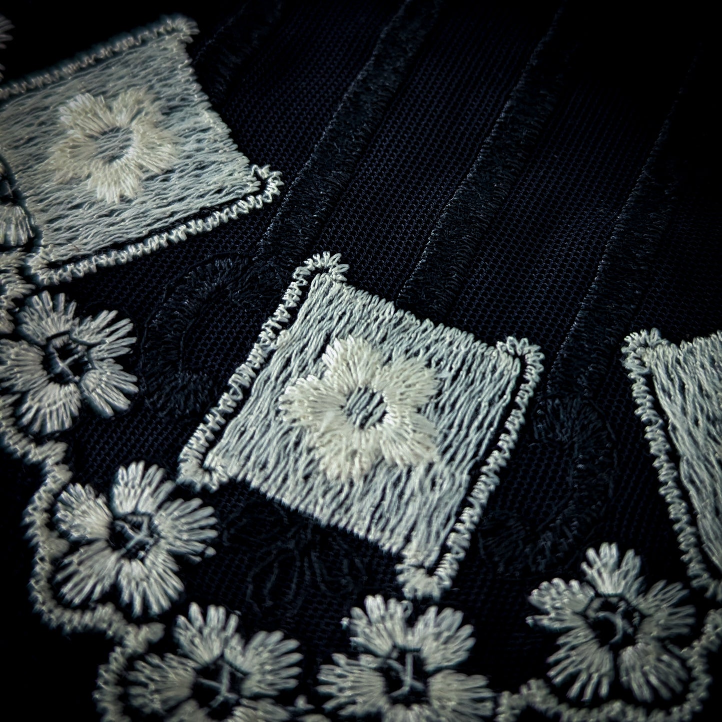 Black tulle ornament with white floral and geometric D&G embroidery, 15x20cm.