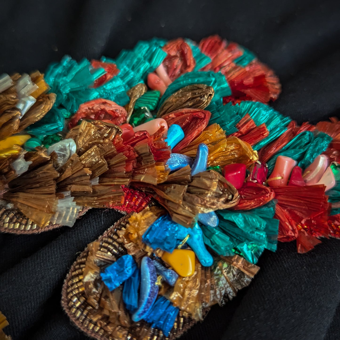 3D D&G Zierelement with colorful raffia, brown, teal, red, and yellow accents, and blue, pink, and yellow beads.
