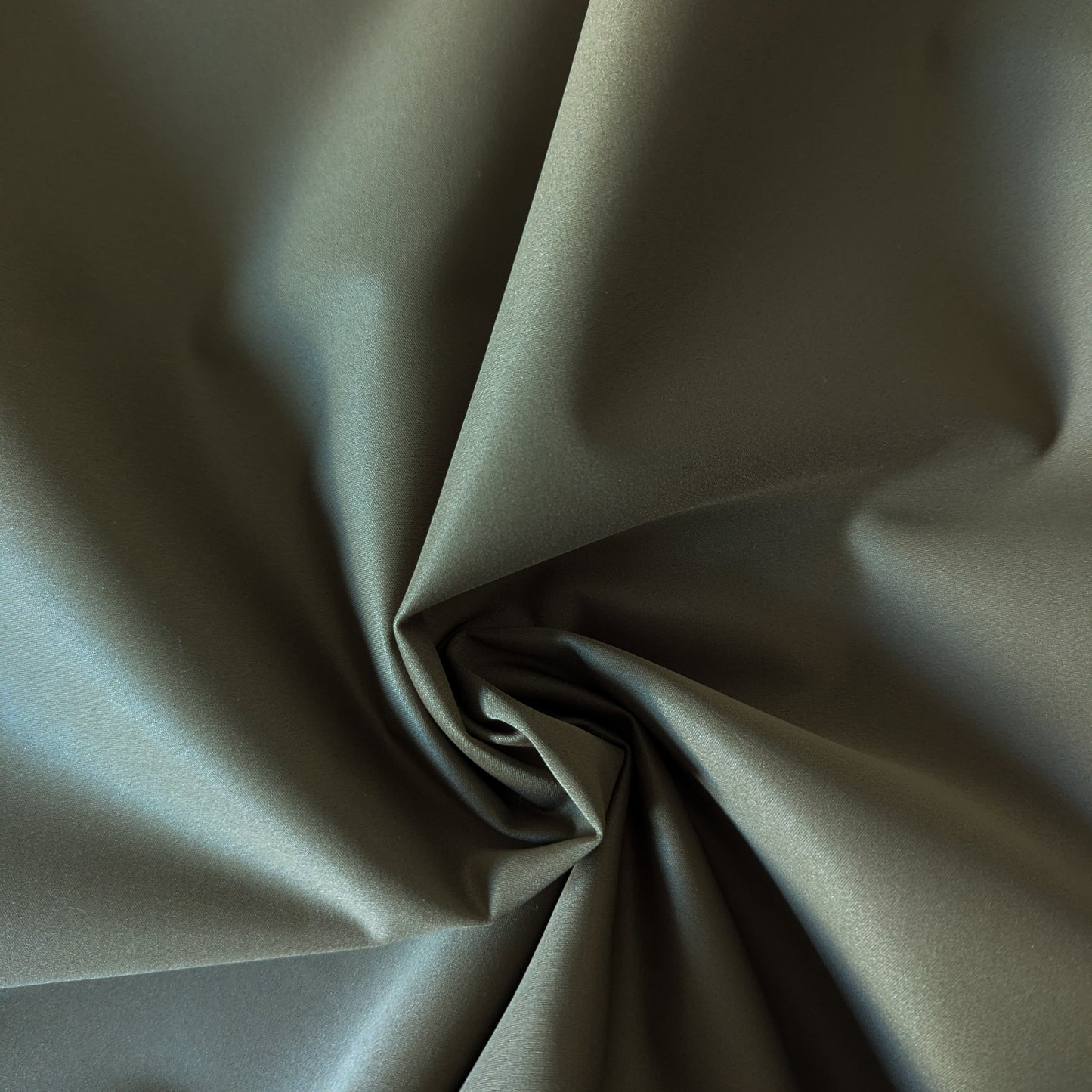 Dark olive green wool-polyester doubleface fabric, softly draped and swirled, showing its smooth texture.