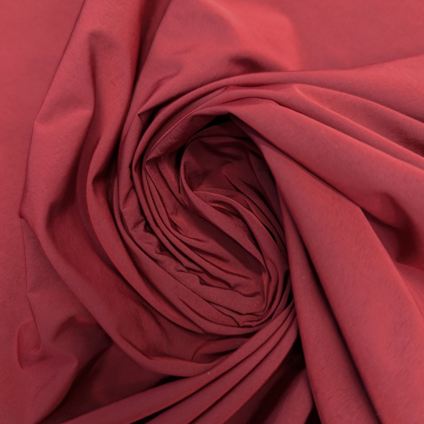 Deadstock Taffeta fabric in Pantone Rythmic Red, 120 cm wide, with a subtle sheen and elegant folds.
