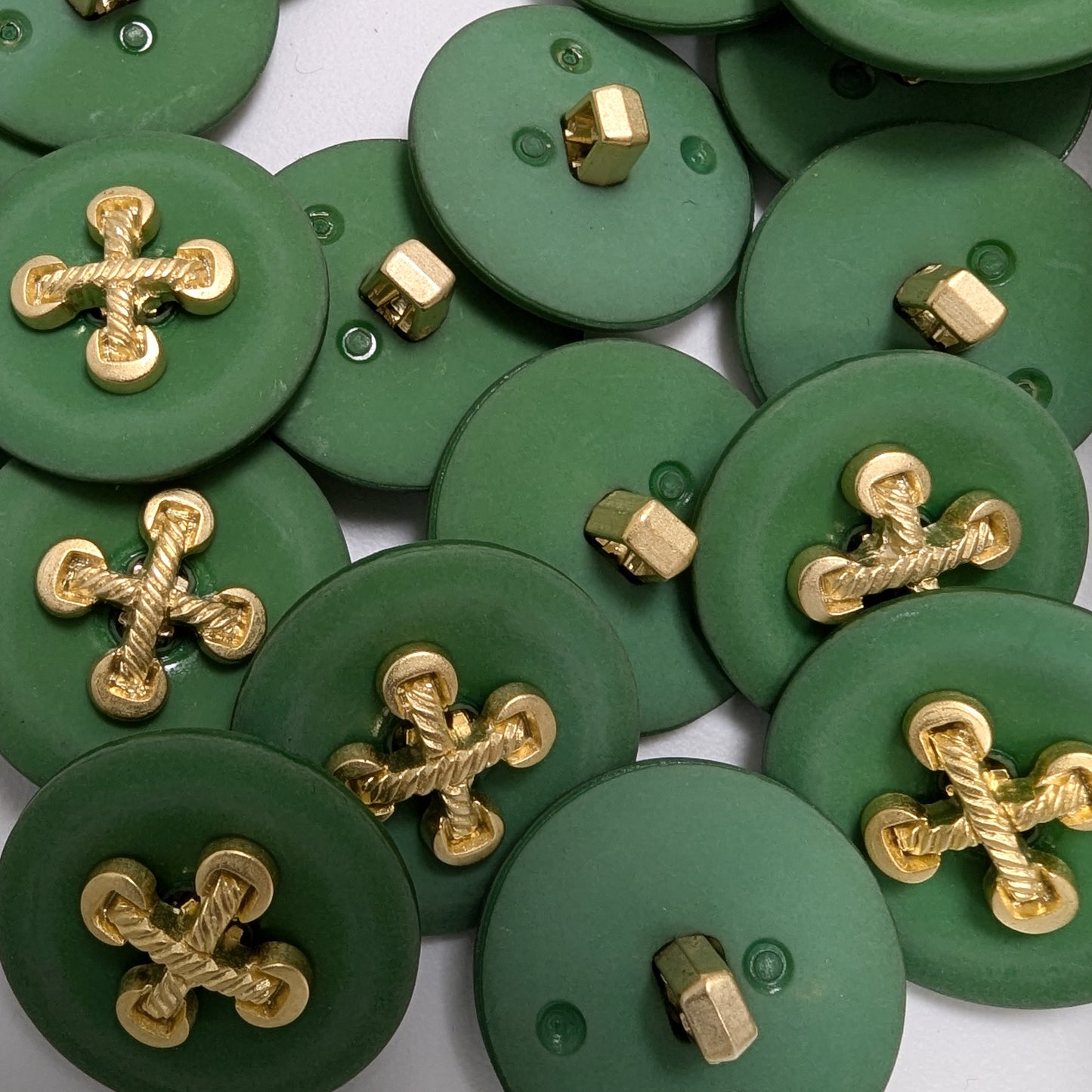 Matte green buttons with shiny gold-tone metal cross-knot accents, approximately 2.3 cm.