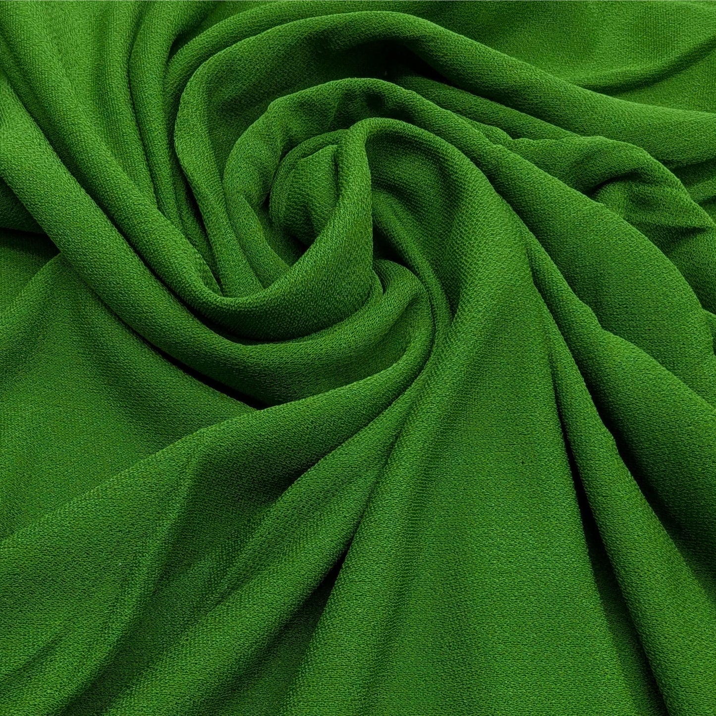 Deadstock D*or viscose crepe fabric in a vibrant matte green, draped with soft folds.