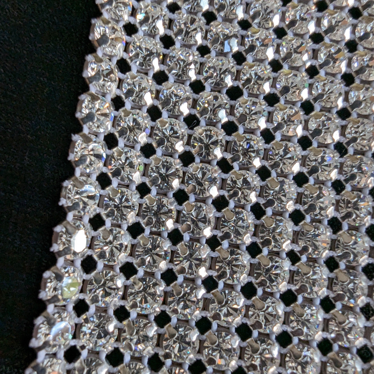 Close-up of a sparkling D&G Swarovski & Kristall patch, featuring numerous clear rhinestones on a mesh backing.