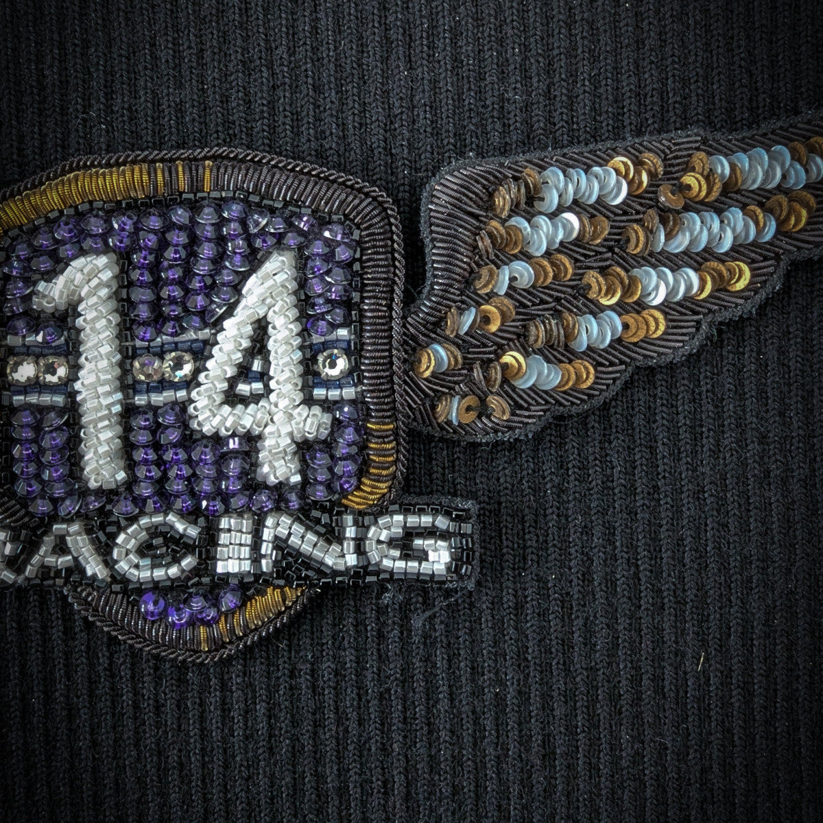 D&G 16cm racing patch with purple and white beads, gold trim, and sequined wings on black fabric.