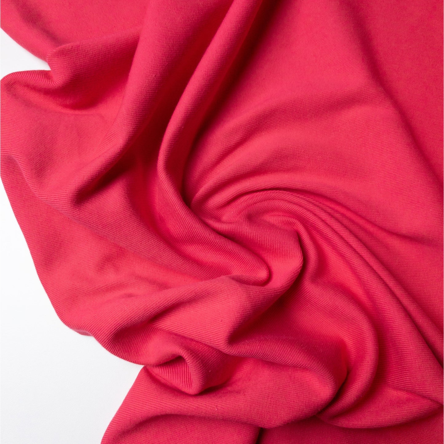 Fuchsia pink ribbed knit deadstock fabric, 105 cm wide, draped with soft folds.