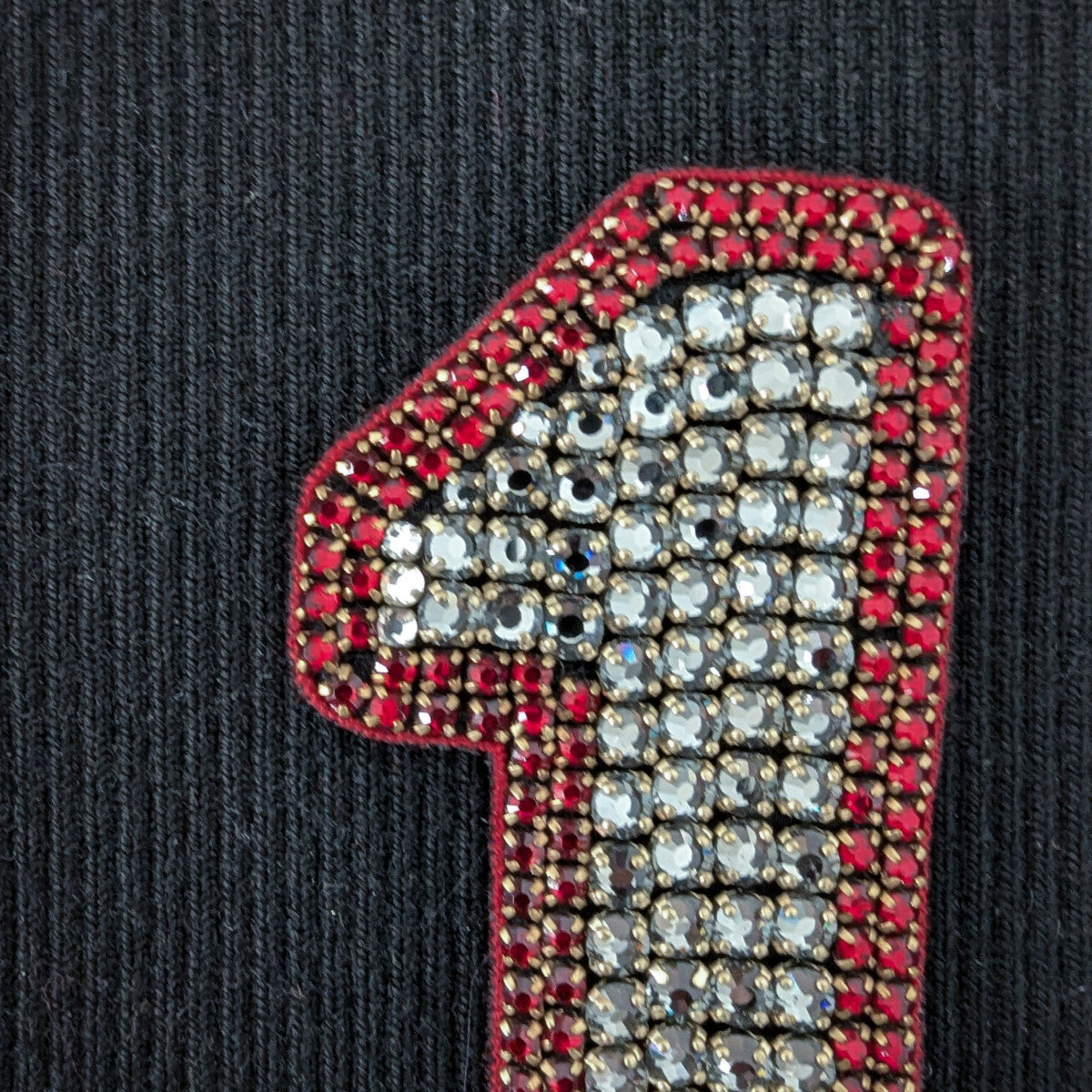 D&G red and silver beaded number "1" patch with pearl embroidery on a dark background.