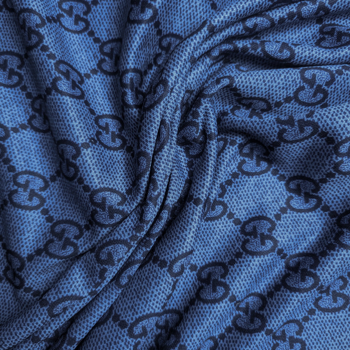 Blue Punto Milano deadstock fabric with dark designer monogram pattern and subtle texture.