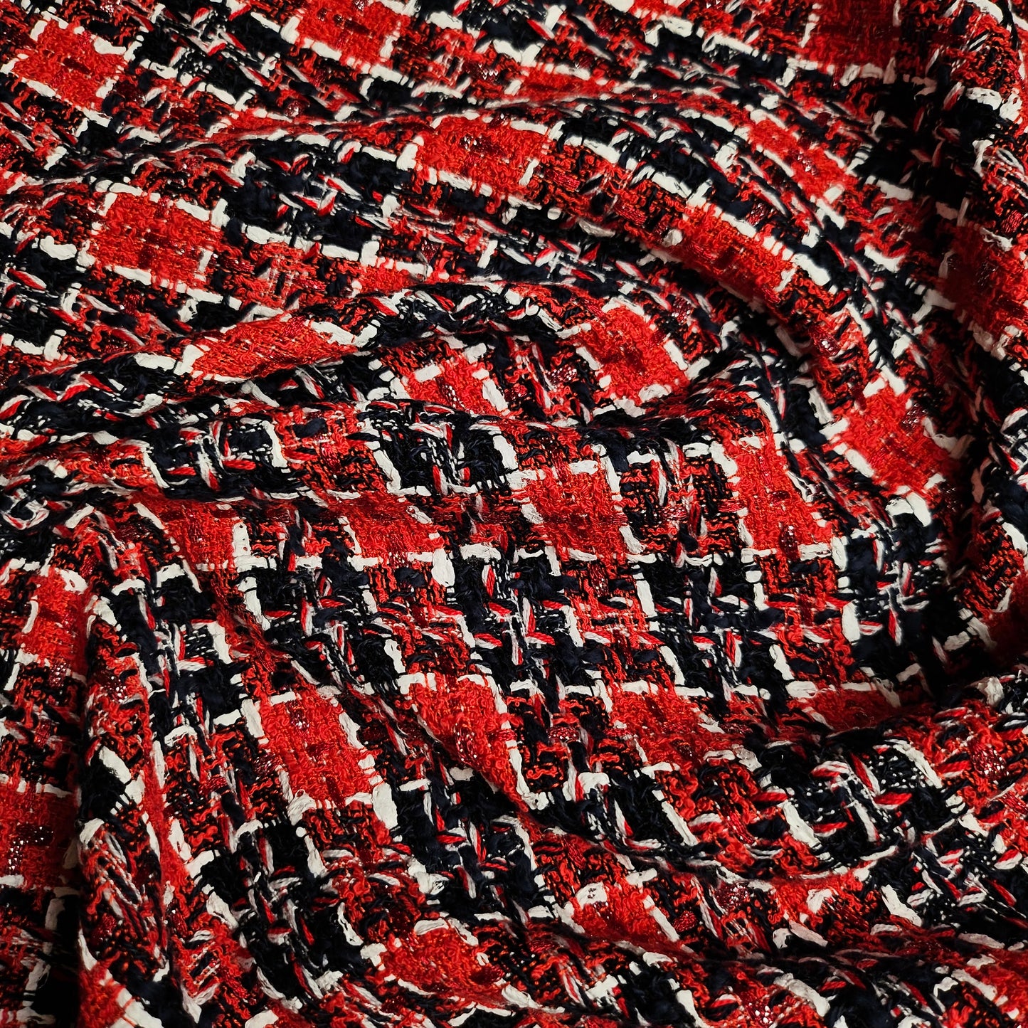 Red, black, and white tweed fabric with a textured weave, suitable for fashion projects.