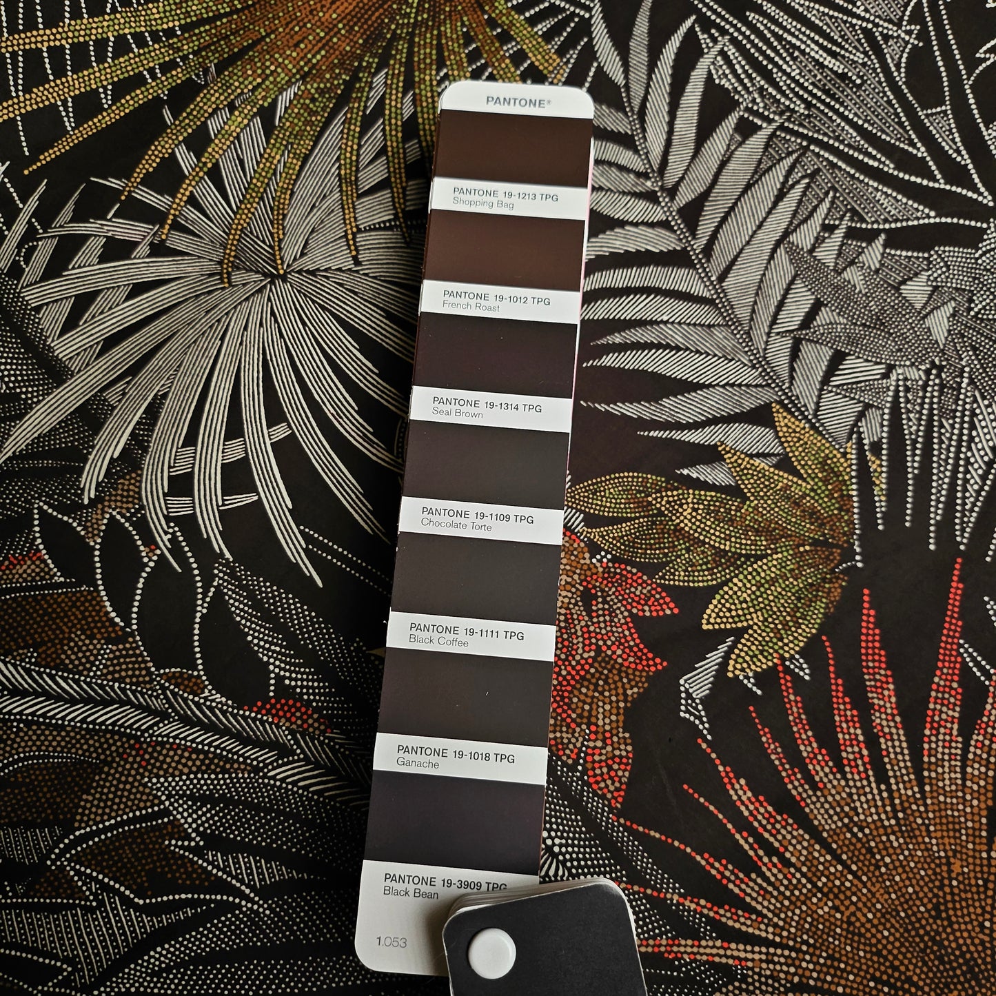 Deadstock Kunstfaser Webware, 140cm, with a dark tropical leaf pattern and a Pantone Seal Brown color swatch.