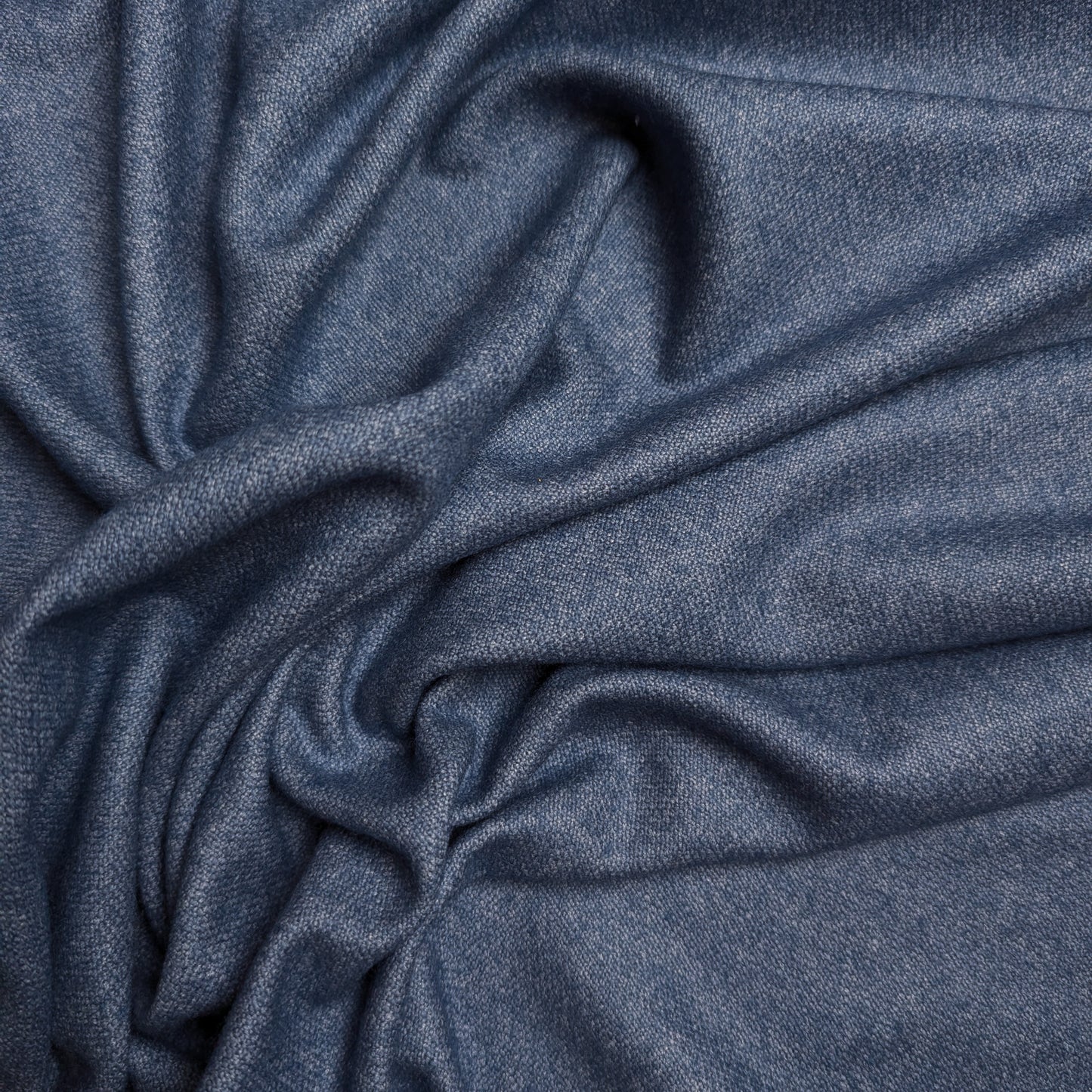 Stonewashed blue wool-cashmere blend deadstock fabric, draped with soft folds.