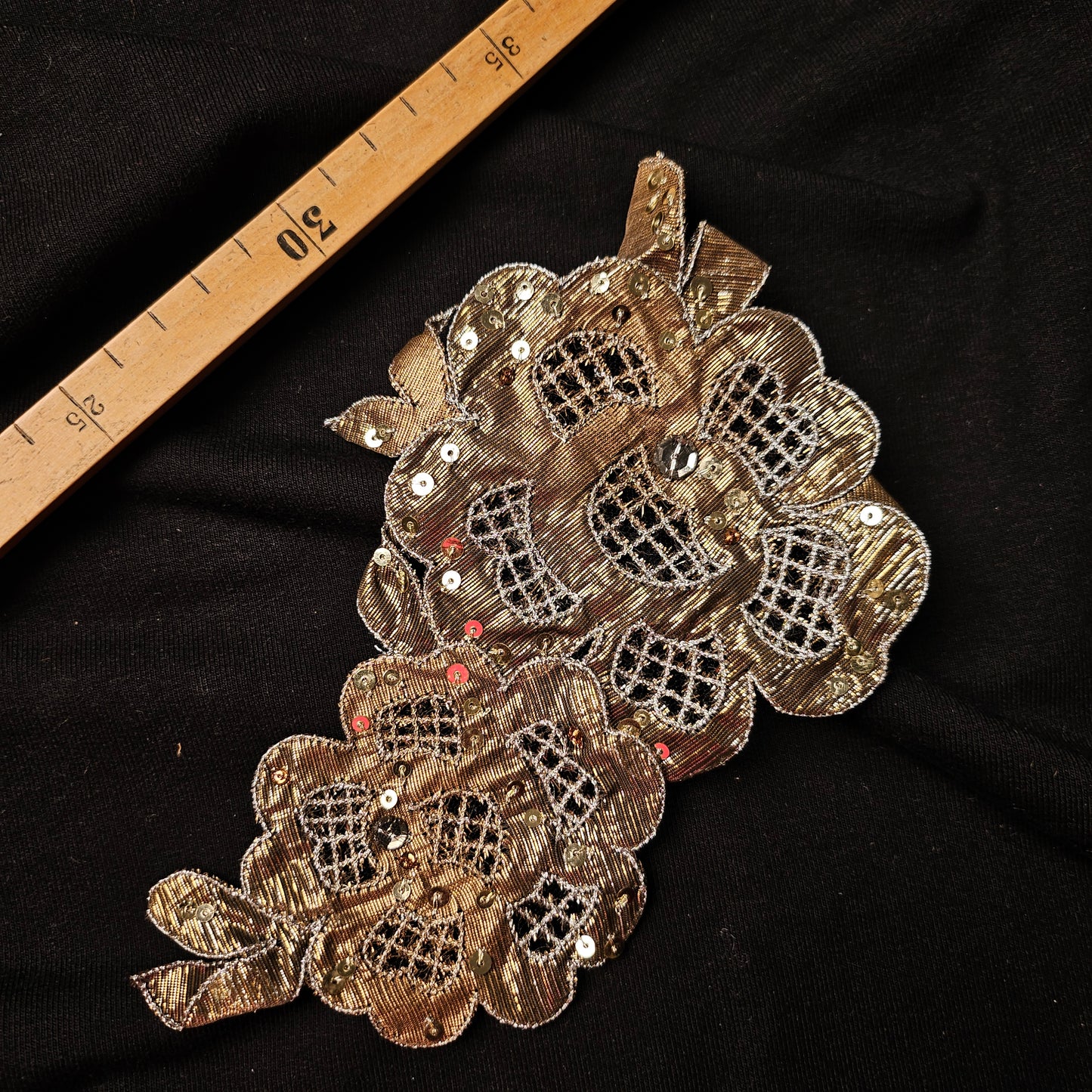 Gold D&G lace floral patch with sequins, 10x19 cm, on black fabric with a ruler.
