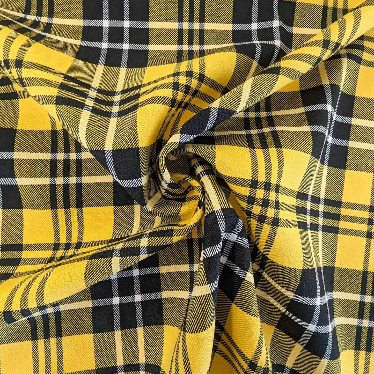 Deadstock yellow, black, and white plaid wool fabric, 145 cm wide, with soft folds.