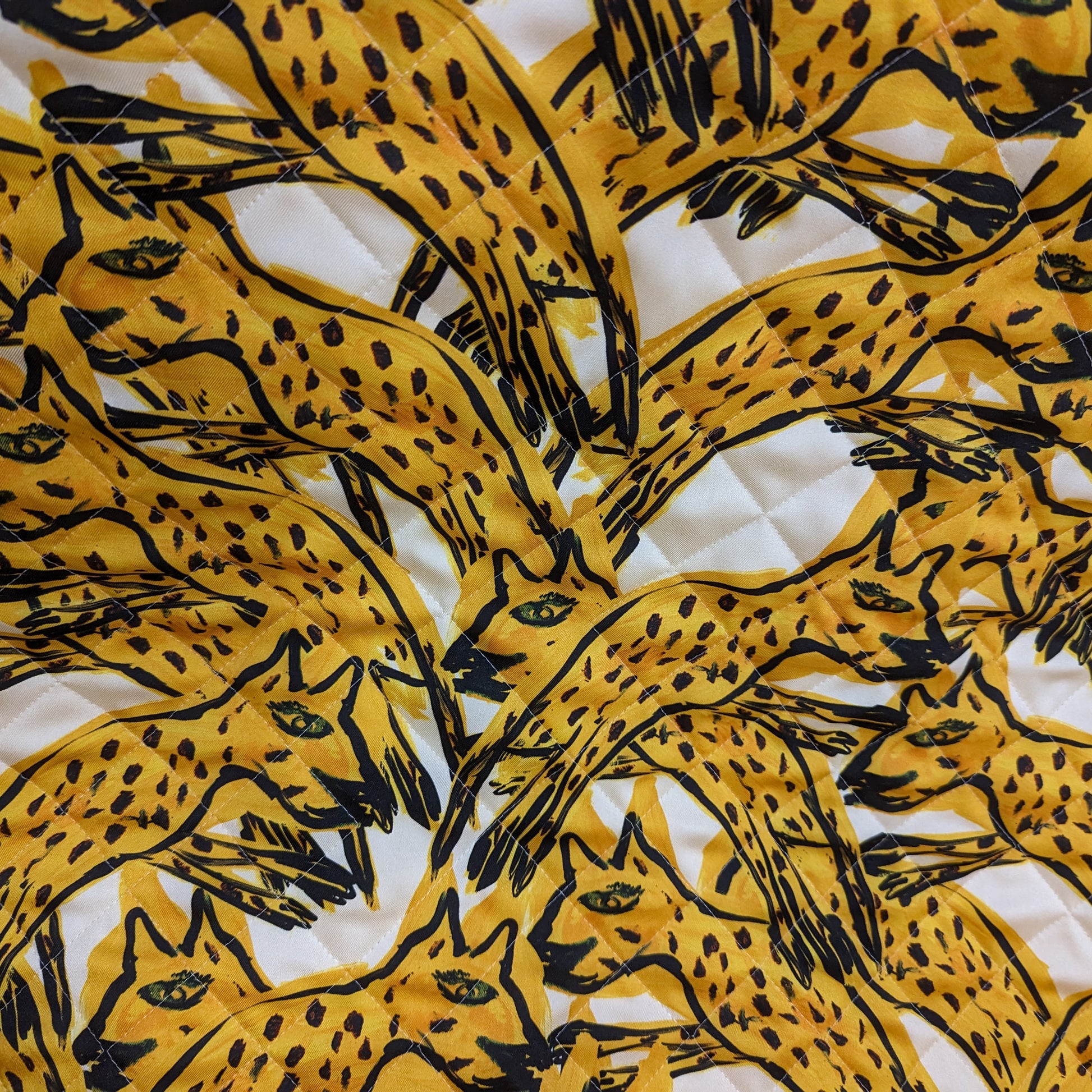 AZ-Factory deadstock quilted fabric: yellow & black leopard print on white, lightly padded with diamond stitching.