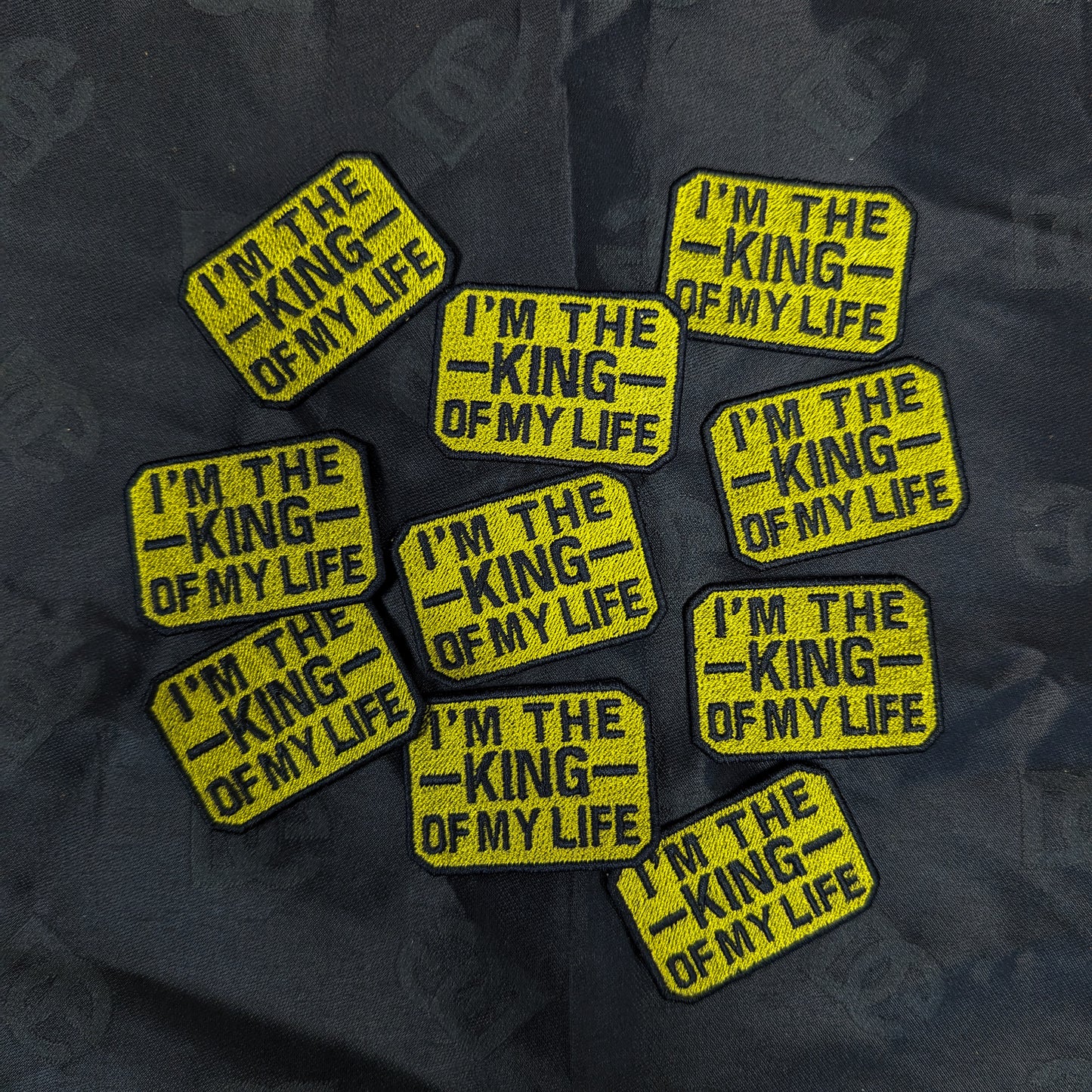 Yellow embroidered "I'm the King of My Life" patches, 4x5cm, on a dark fabric.