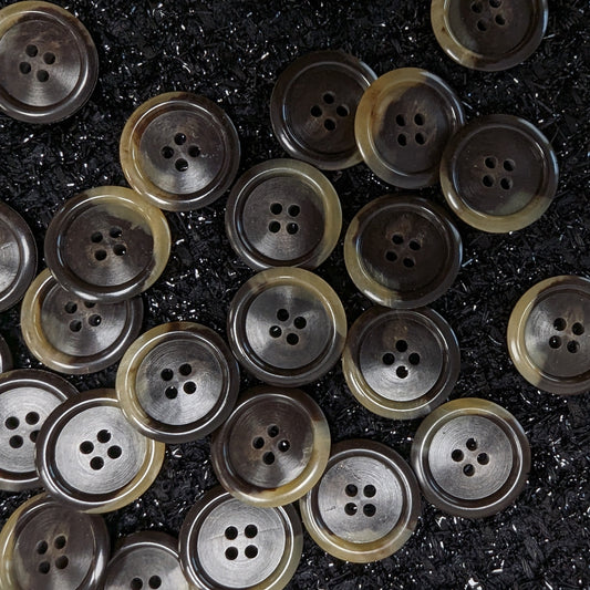 Round, 2.5cm, dark brown and beige marbled buttons with four holes, scattered on a black textured surface.