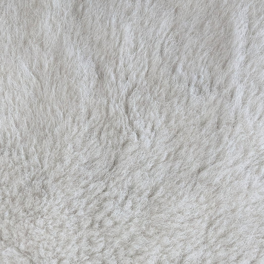 Close-up of luxurious D*or deadstock wool-cotton teddy fabric in creamy off-white, soft and fluffy.