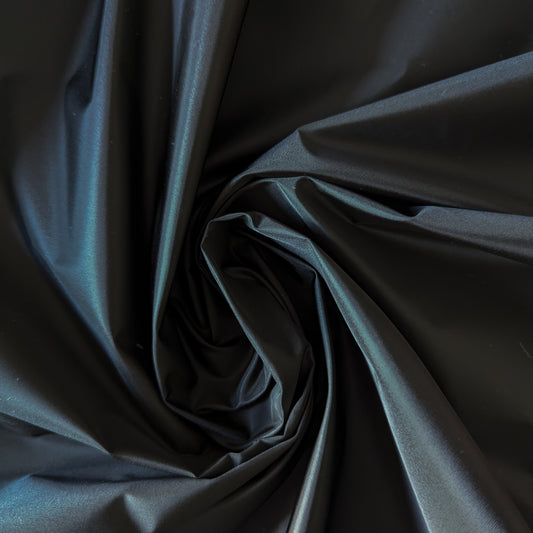 Jet black P###a deadstock nylon fabric, 130cm wide, with subtle sheen and soft folds.