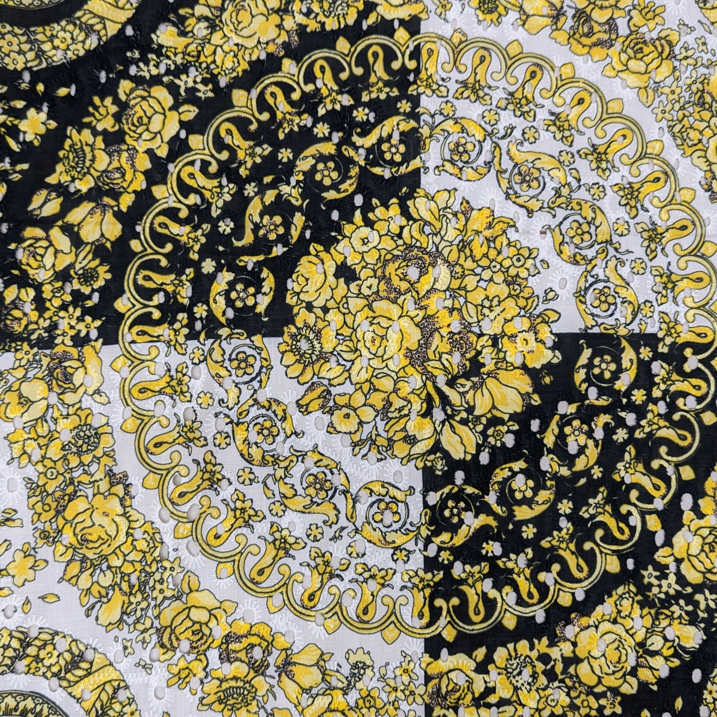 Deadstock Sangallo lace panel with yellow Medusa print and floral patterns on black and white.