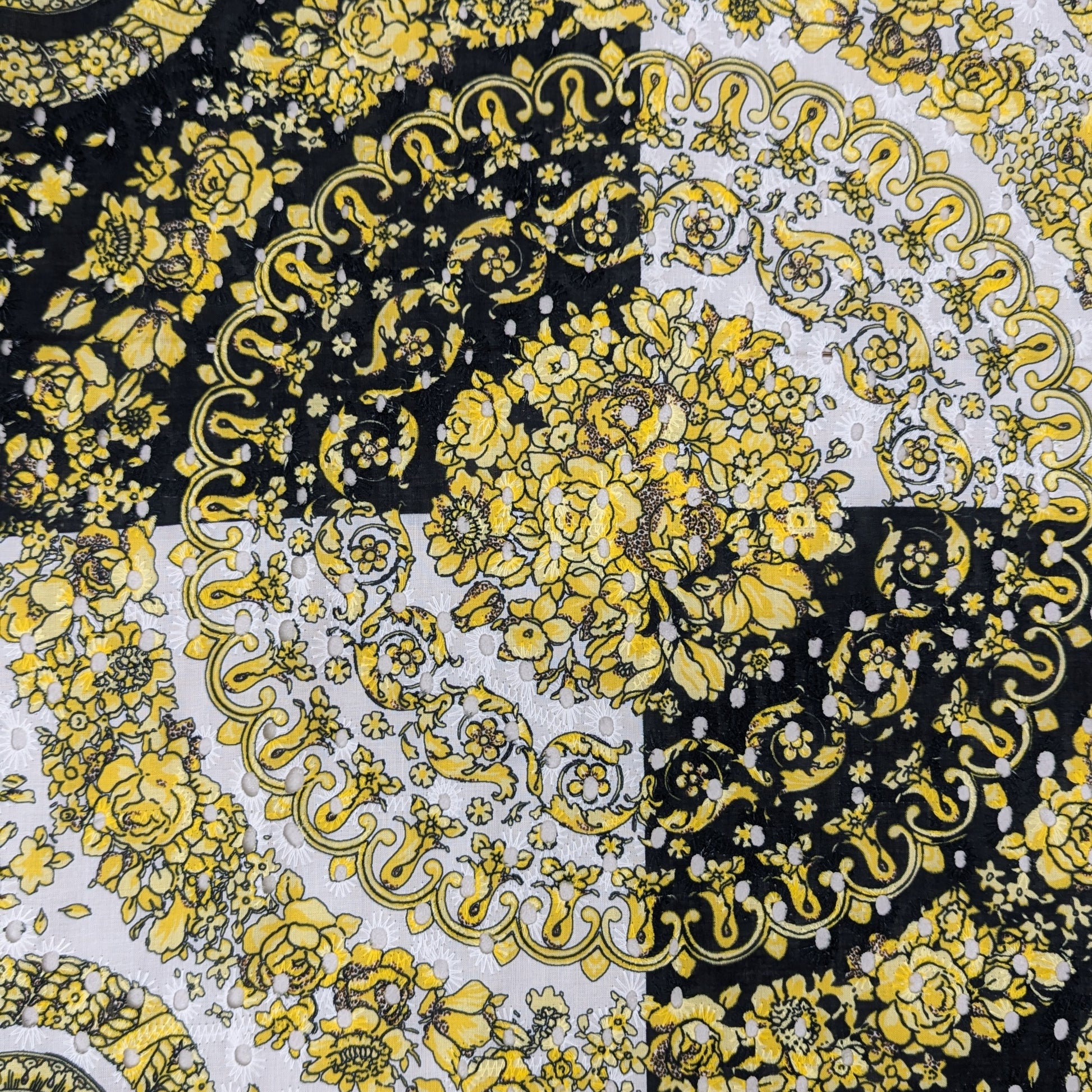 Deadstock Sangallo lace panel with yellow Medusa print and floral patterns on black and white.