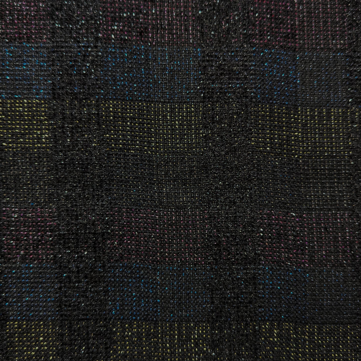 Close-up of dark doubleface tweed fabric with colorful flecks and subtle horizontal stripes.