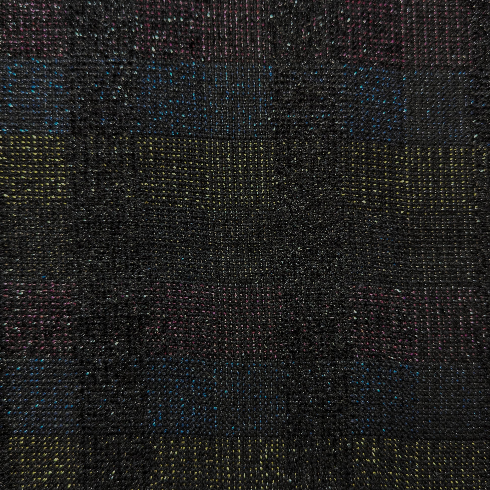 Close-up of dark doubleface tweed fabric with colorful flecks of blue, yellow, and pink.