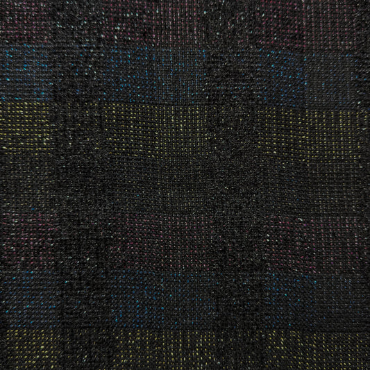 Close-up of dark doubleface tweed fabric with colorful flecks of blue, yellow, and pink.