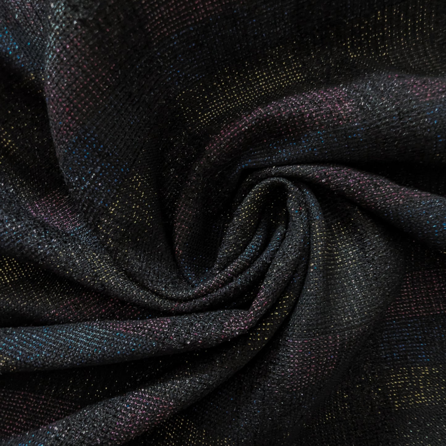 Dark doubleface tweed fabric with subtle colorful flecks, folded in a swirl.