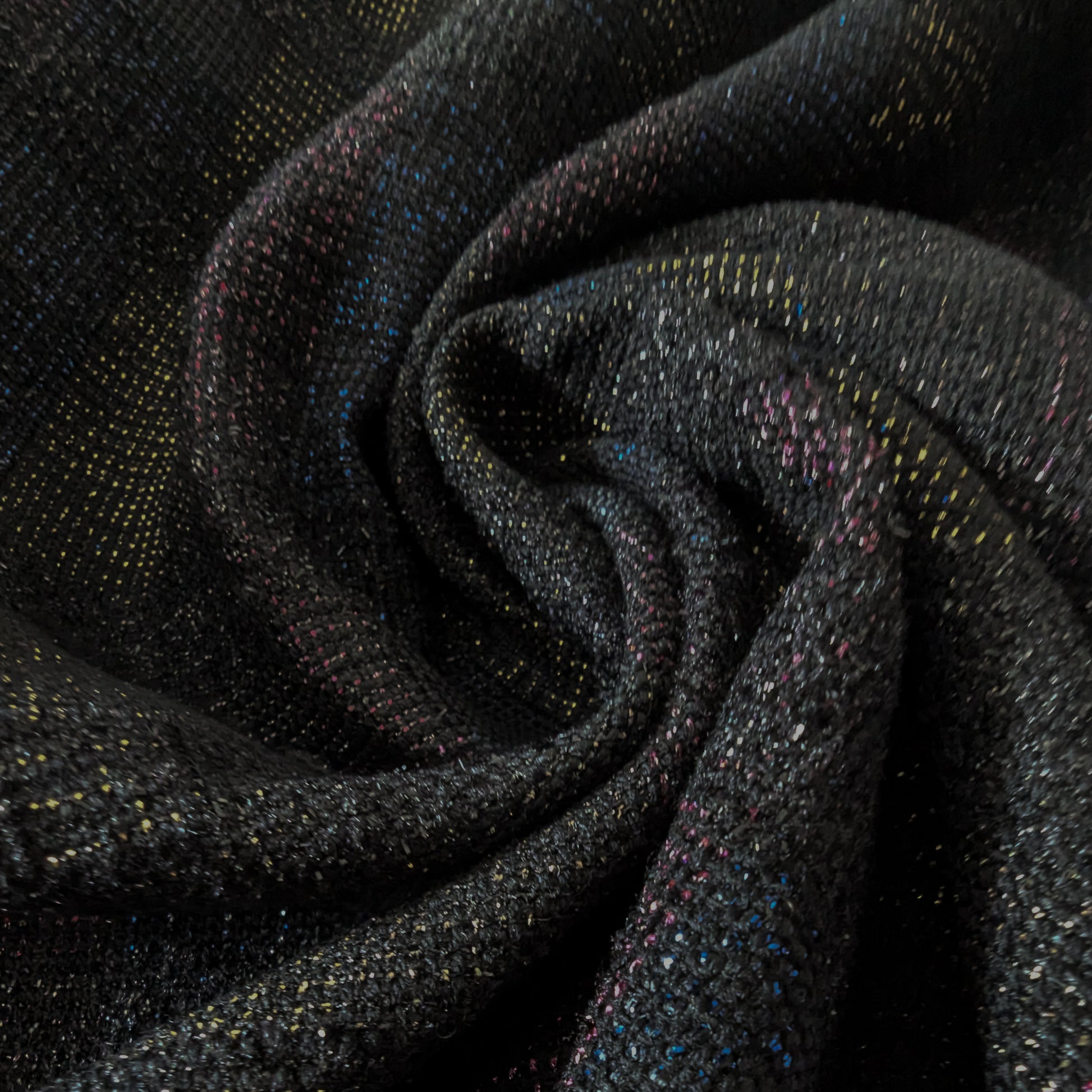 Dark gray doubleface tweed fabric with colorful flecks, draped in soft folds.