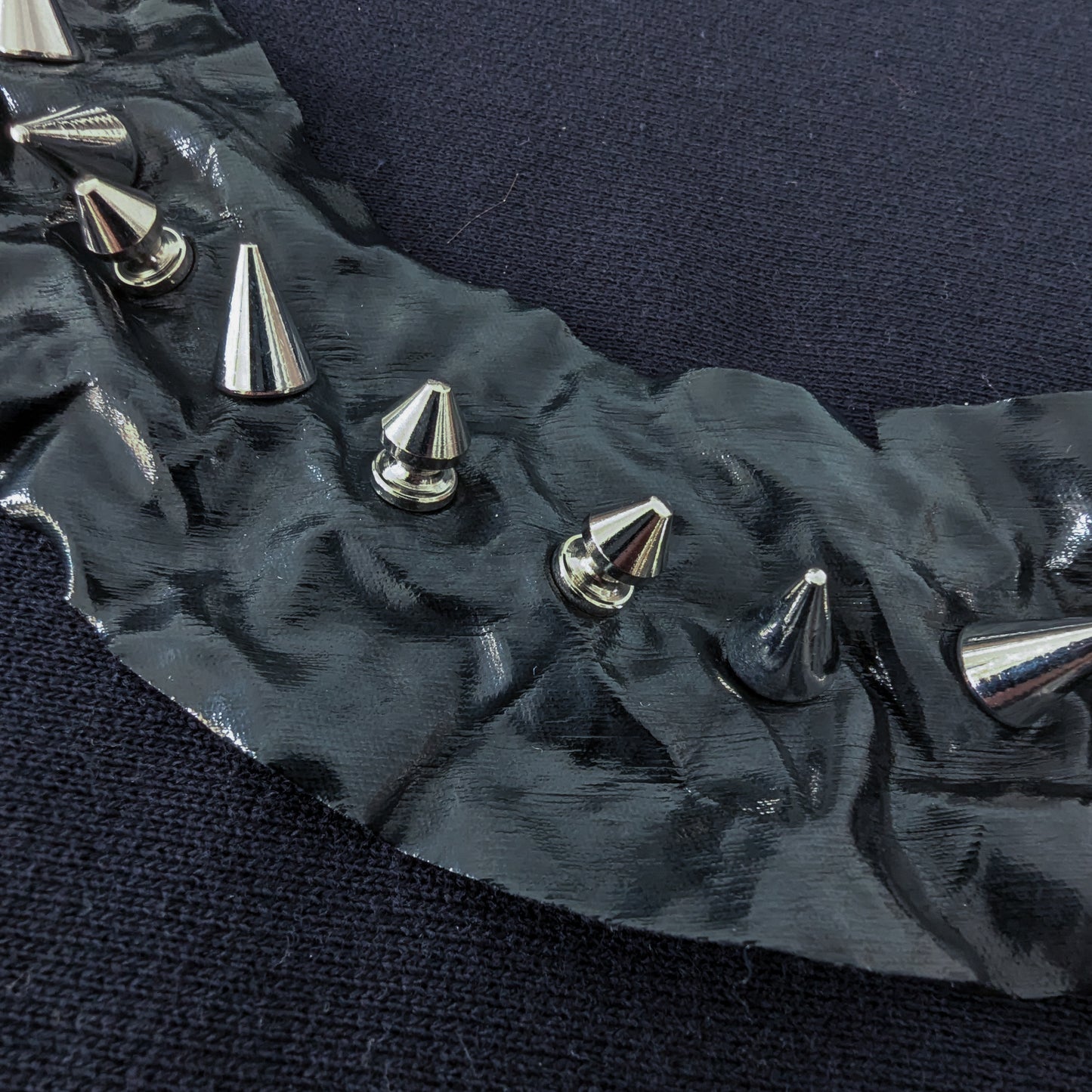 Black patent fabric collar with 18 silver screw studs, 5cm wide, 85cm long.