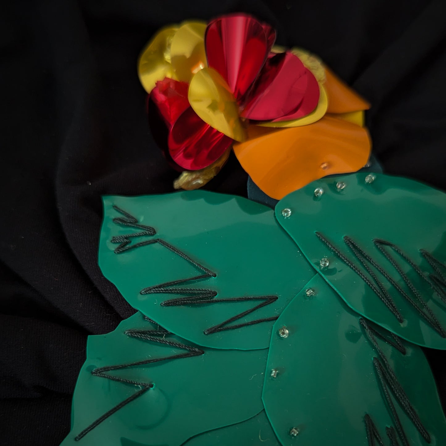 D&G plastic flower patch, 13x19cm, with shiny red, yellow, orange petals and green leaves.