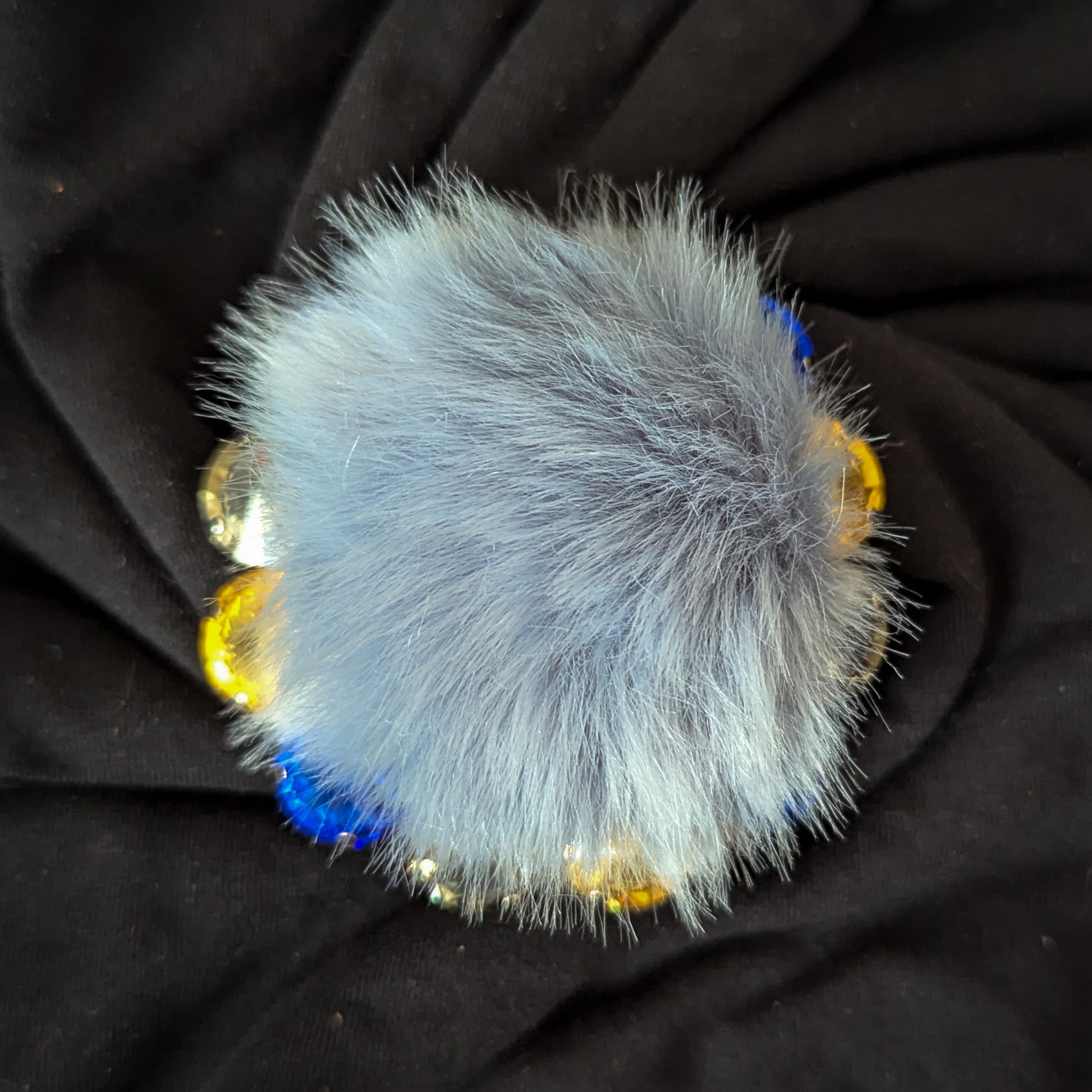 Blue-gray faux fur ornament with gold and blue Swarovski crystals, 7cm x 7cm.