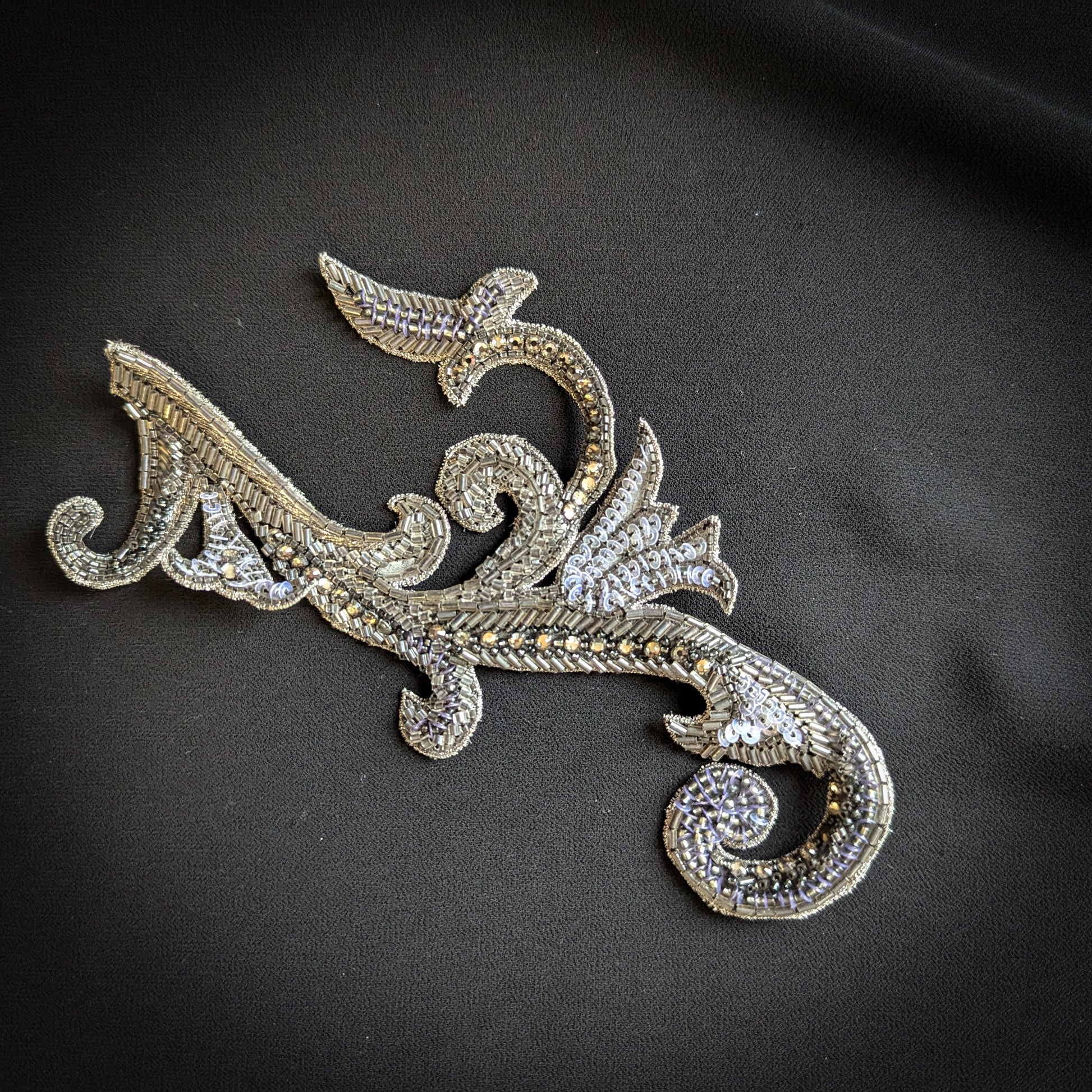 Silver metal and pearl appliqué, 7x17cm, with intricate scrollwork and bead details.