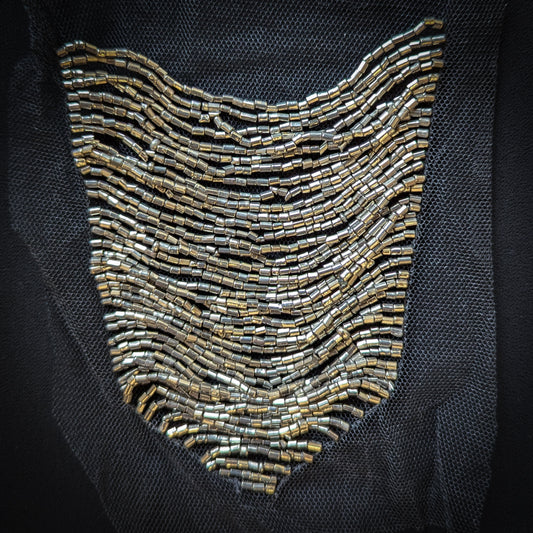 Silver beaded crest-shaped tulle patch, 12x15cm, on black mesh.
