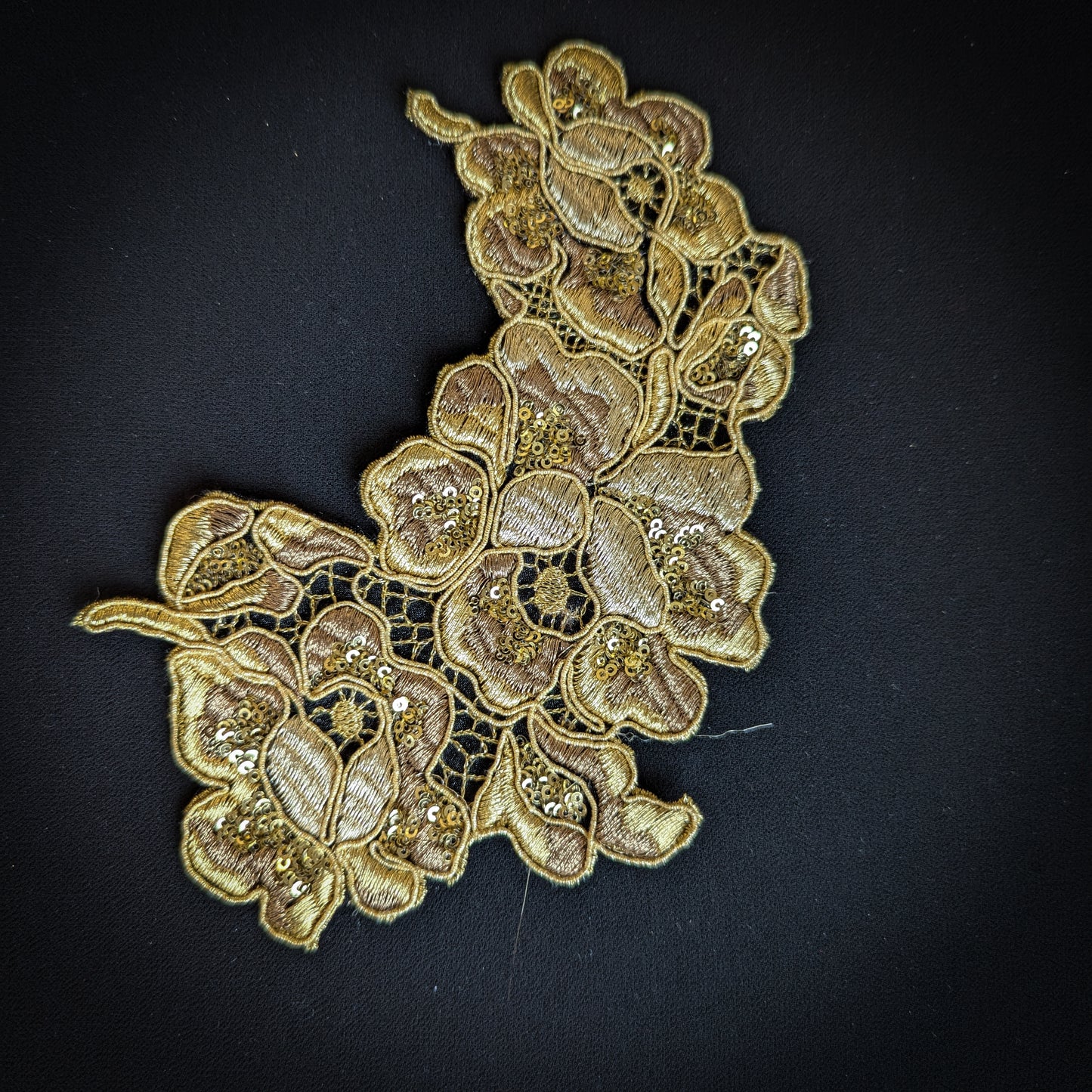 Gold lace appliqué with sequins, 10x15 cm, featuring intricate floral embroidery on black fabric.
