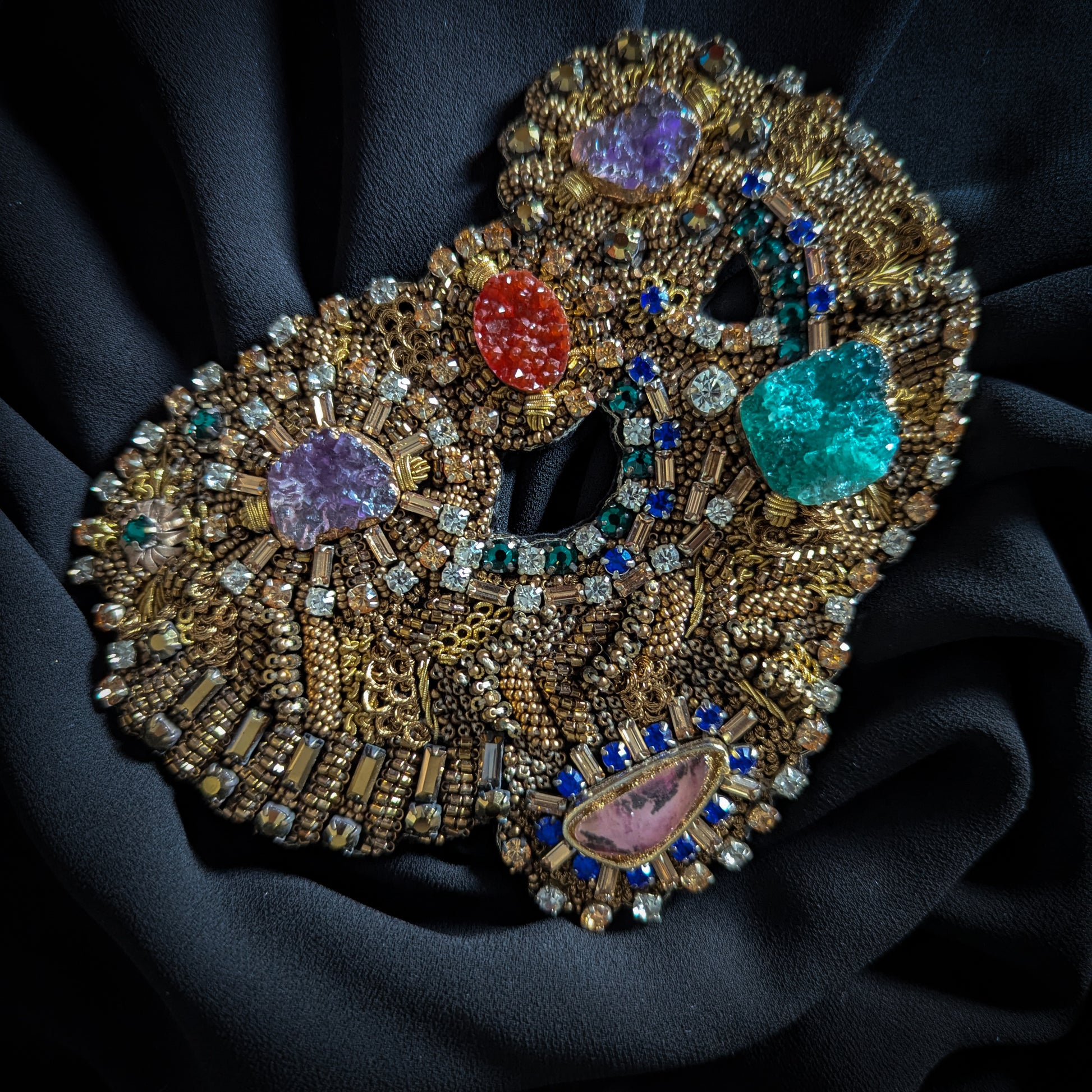 Heavy gold embroidered patch with colorful faceted gemstones, Swarovski crystals, and pearls on black fabric.