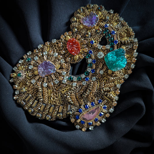 Heavy gold embroidered patch with colorful faceted gemstones, Swarovski crystals, and pearls on black fabric.