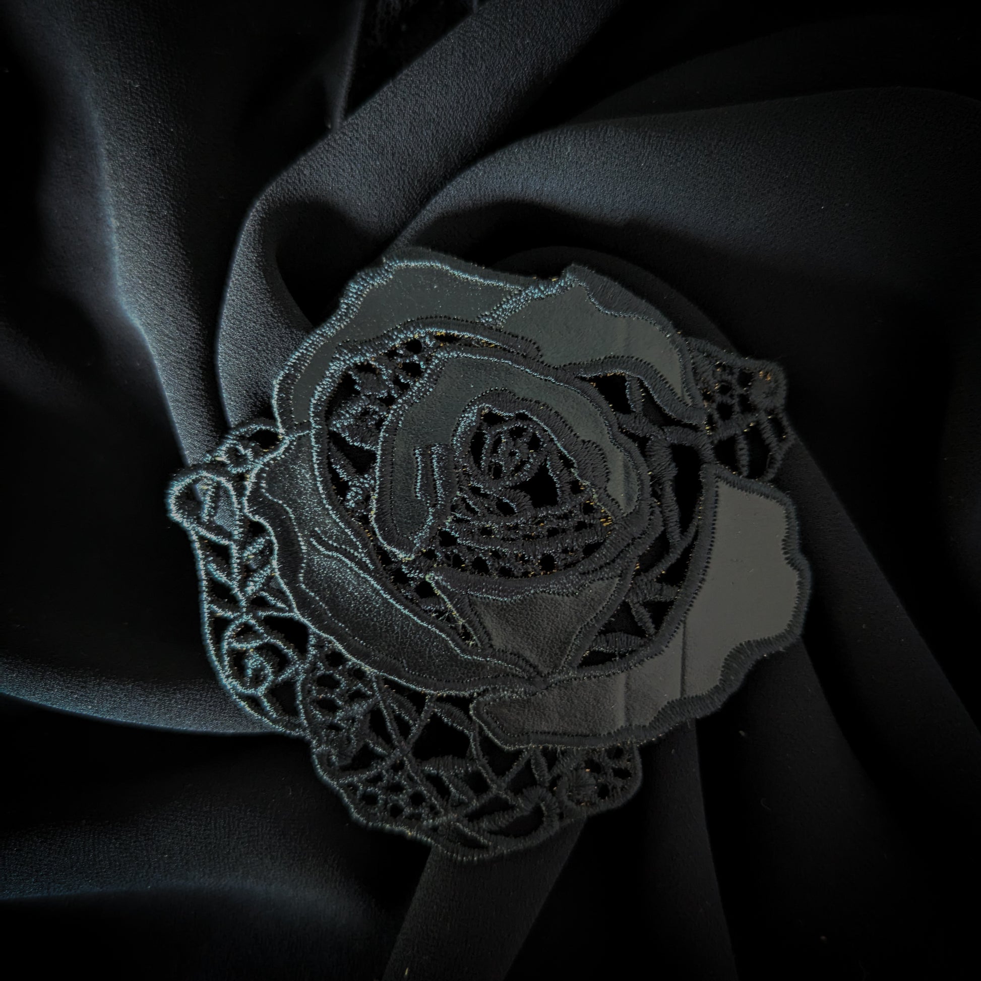 Black D&G rose patch with intricate lace and leather details, 8x9 cm, on dark fabric.