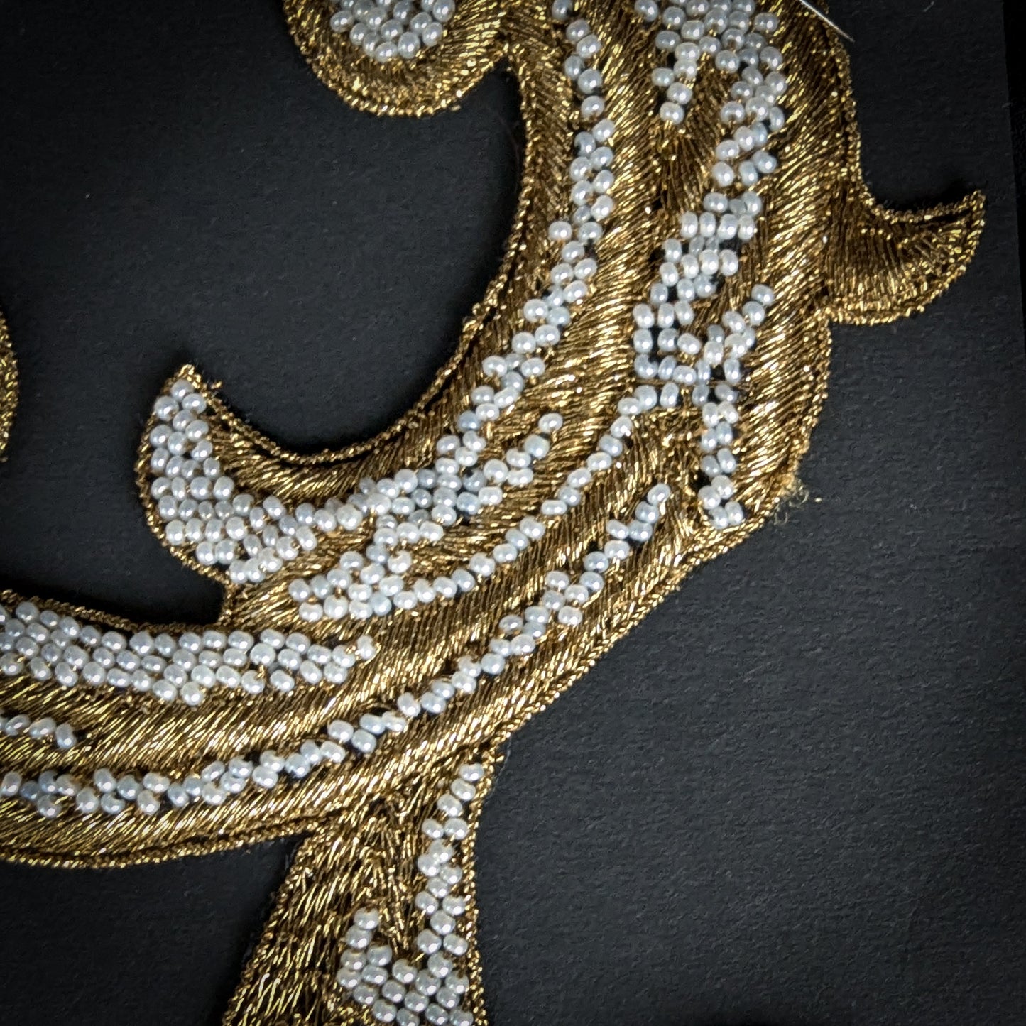 D&G gold metallic embroidery patch with white pearls, 9x14cm, on a black background.