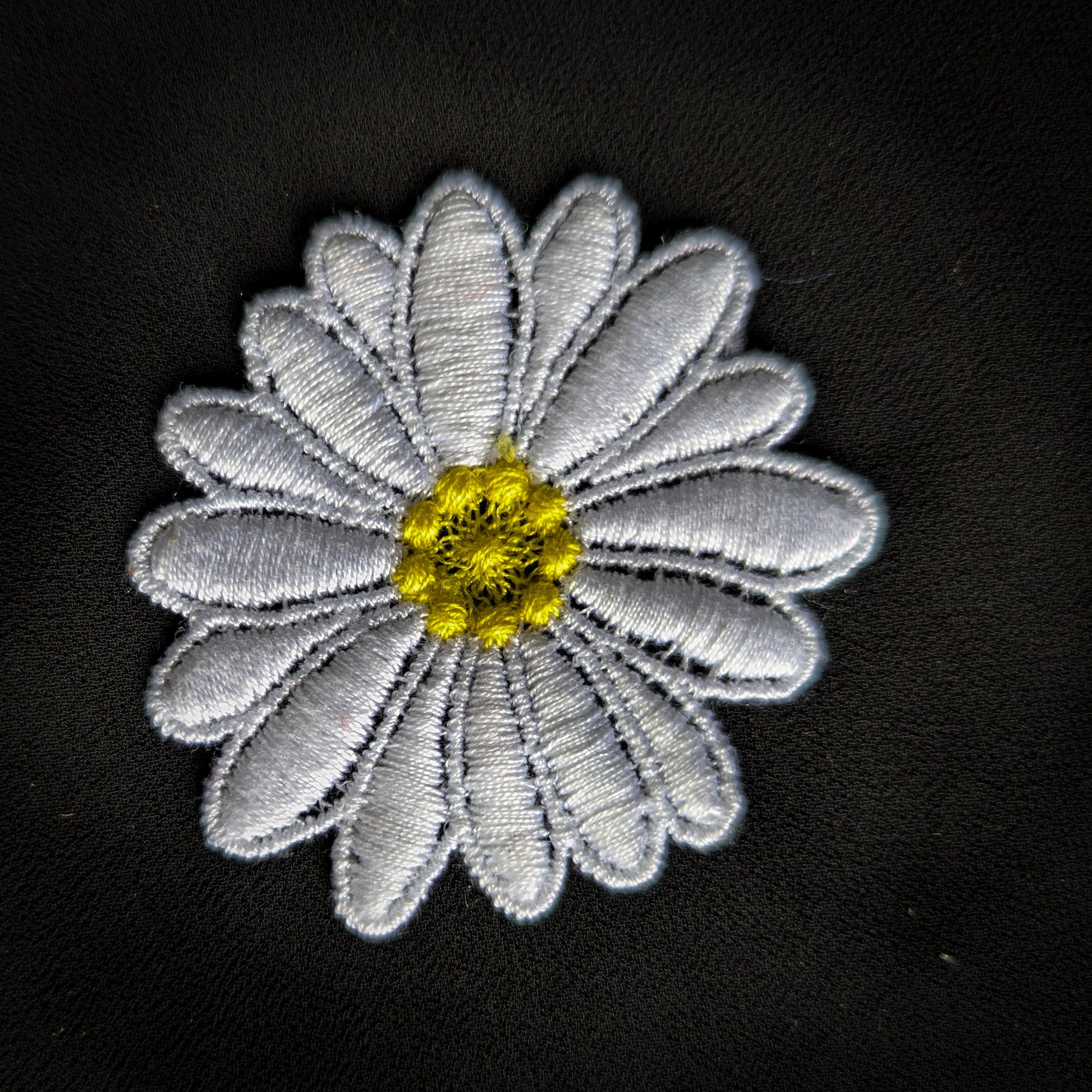 D&G large white daisy patch with yellow center, 10x11cm, embroidered on black fabric.