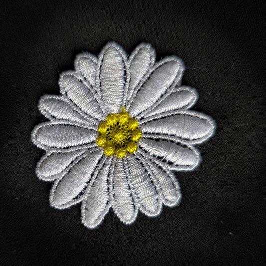 D&G large white daisy patch with yellow center, 10x11cm, embroidered on black fabric.