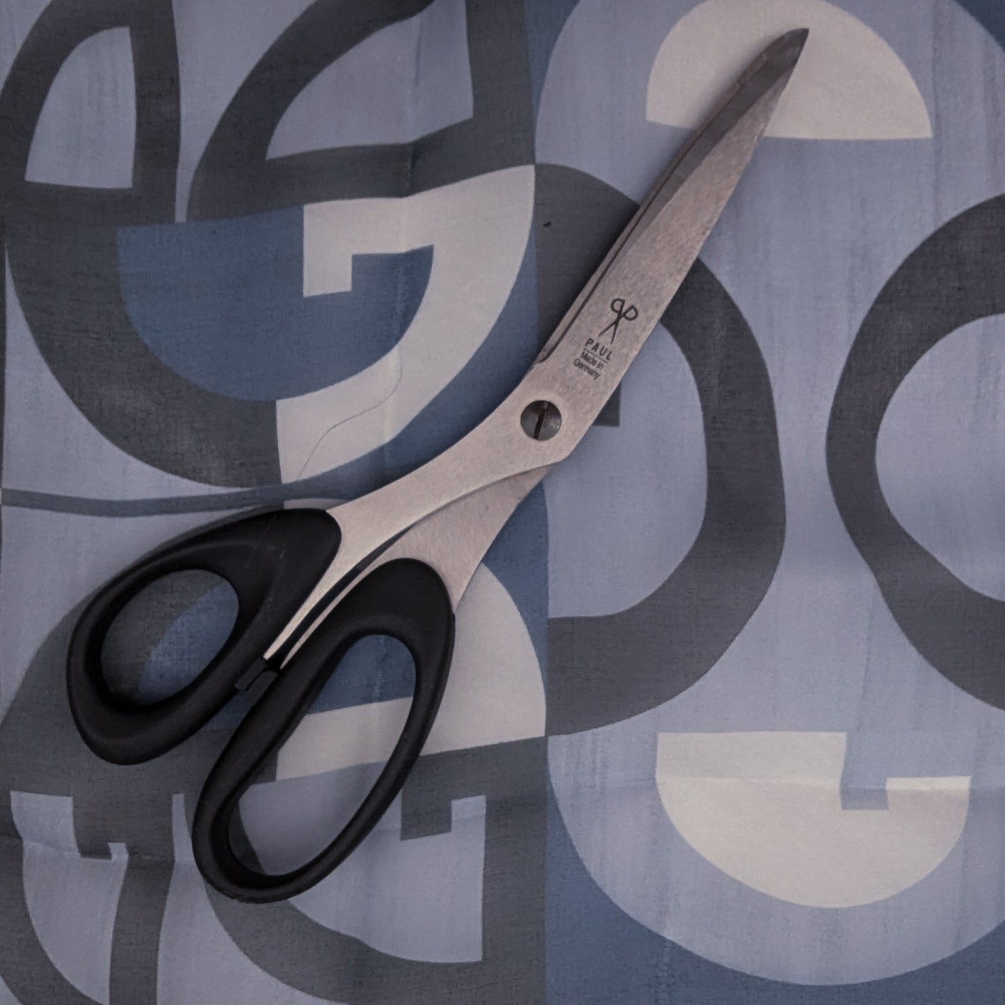D&G deadstock blue and grey geometric silk chiffon fabric with black-handled sewing scissors.