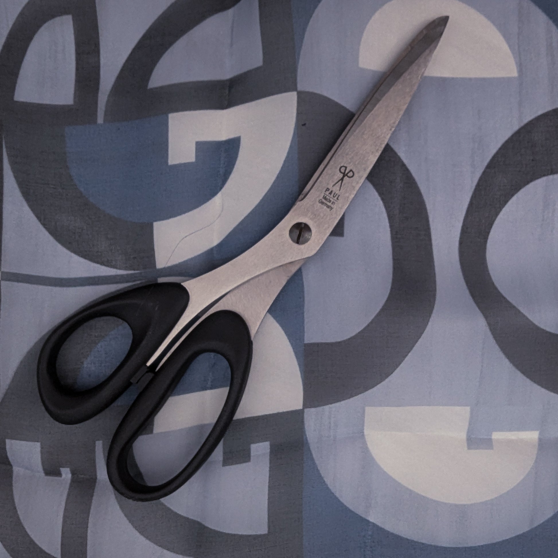 D&G deadstock blue and grey geometric silk chiffon fabric with black-handled sewing scissors.