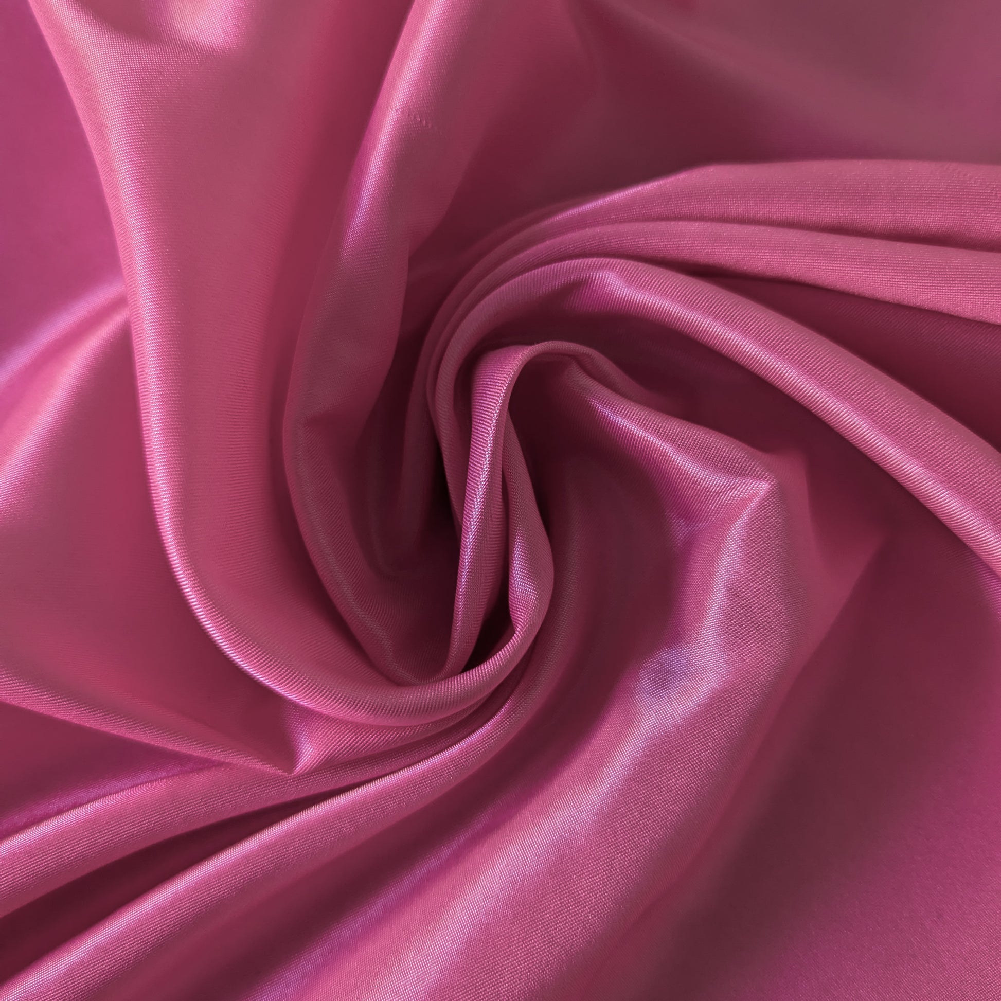 Swirled G*cci deadstock malve viscose-acetate lining fabric, highlighting its fine, glossy texture.