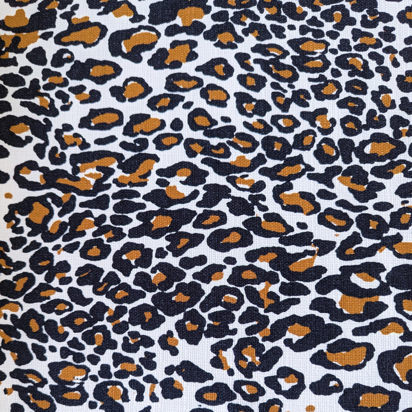 Deadstock cotton fabric with a bold black and brown leopard print on a white background.