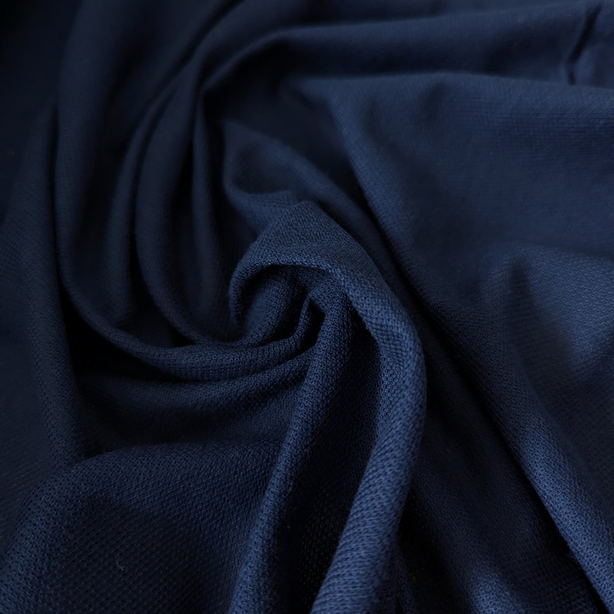 L***e deadstock navy blue cotton-cashmere piqué fabric, soft and structured, draped in a swirl.