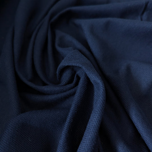 Navy blue cotton cashmere piqué deadstock fabric, 150cm wide, with a subtle textured weave.