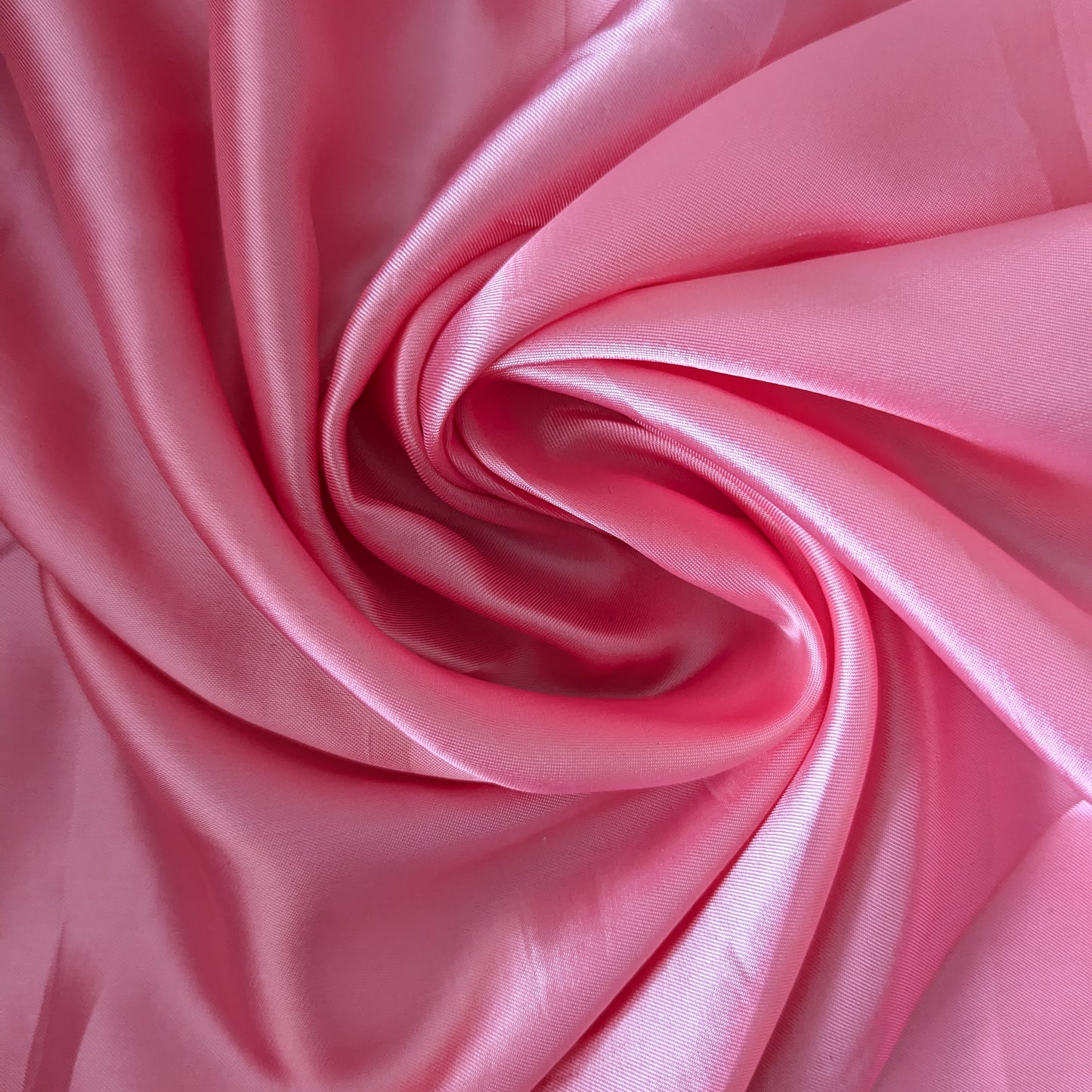 Swirling bubblegum pink Alexander McQueen deadstock viscose lining fabric, smooth and subtly shiny.