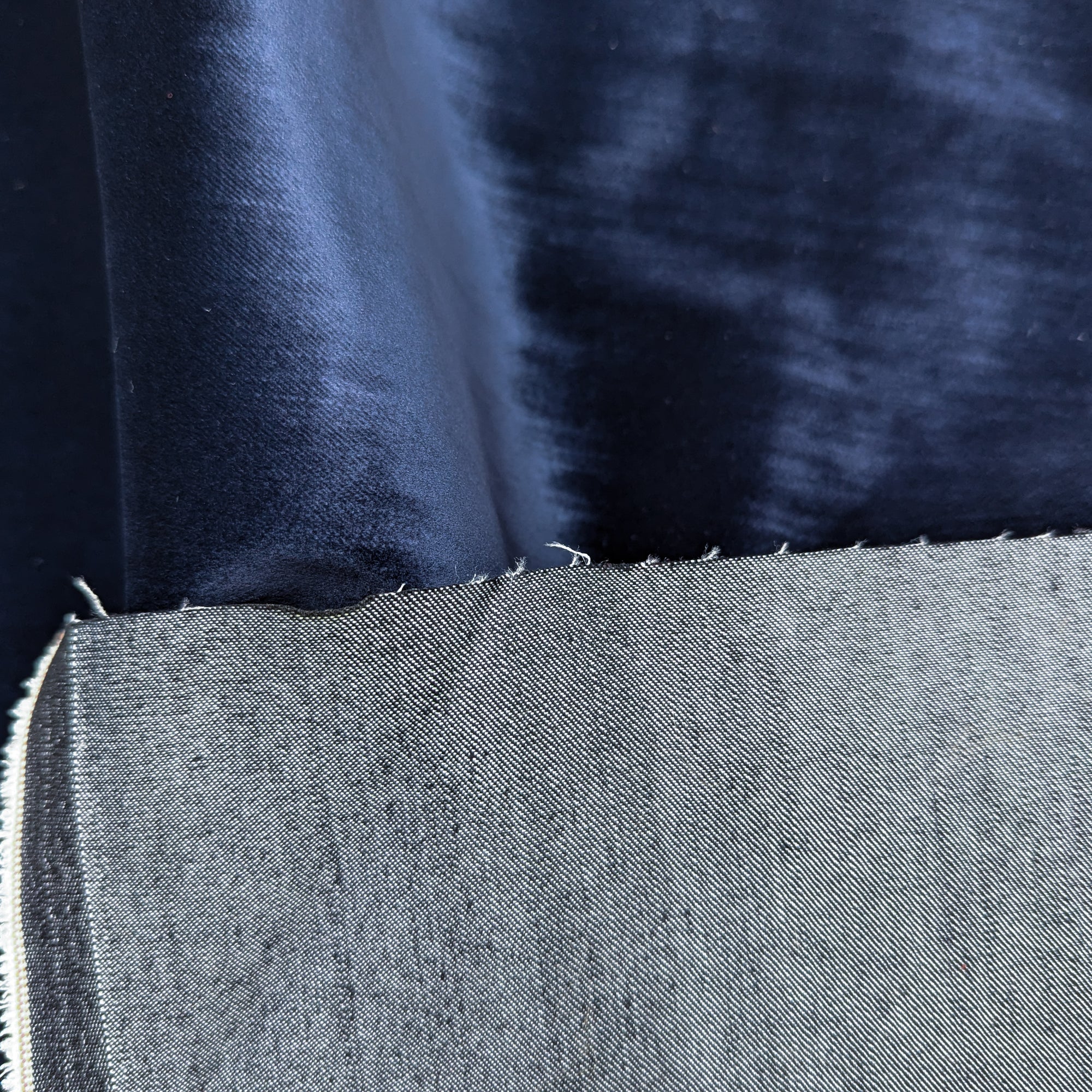 Pantone dark blue velvet denim fabric swatch, showing its soft, plush surface and woven reverse.